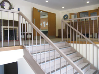These steps lead up to the foyer with the fireplace, the door to the long hallway, and the glassed doors into another foyer overlooking the auditorium.