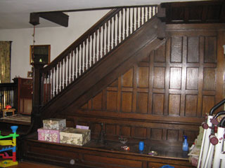 The living room staircase and fireplace as they appear today with Cox family decor.